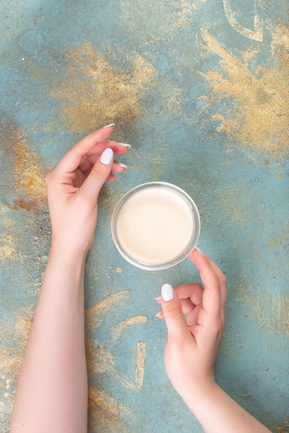 Frauenhände halten Kaffeeglasbecher oder -tasse hochwertiges Foto