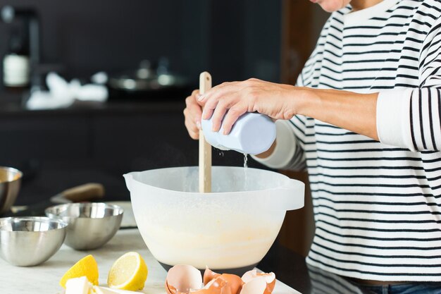 Frauenhände kneten den Teig beim Kochen des Apfelkuchens