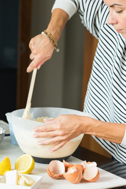 Frauenhände kneten den Teig beim Kochen des Apfelkuchens