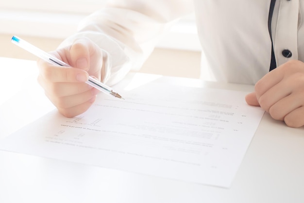 Frauenhände schreiben mit Stift auf Papier