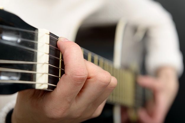 Frauenhände spielen Akustikgitarre, Nahaufnahme