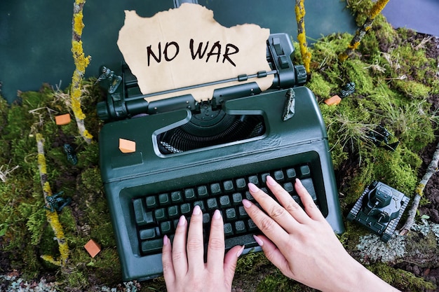 Frauenhände tippen auf einem alten Retro-Schreibmaschinentext - kein Krieg