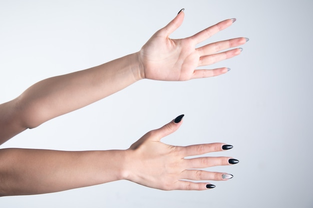 Frauenhände und Finger auf grauem Hintergrund