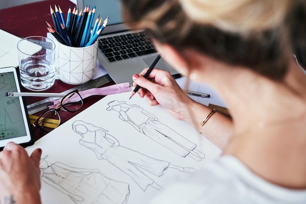 Frauenhände und Modedesignerin zeichnen eine Skizze für die Planung einer Idee oder eines Projekts auf dem Schreibtisch. Die Hand einer kreativen Künstlerin oder eines Grafikdesigners skizziert Kleidungsideen für ein Startup auf dem Tisch