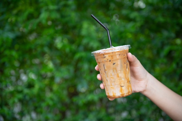 Frauenhand, die den Glas-Eiskaffee hält