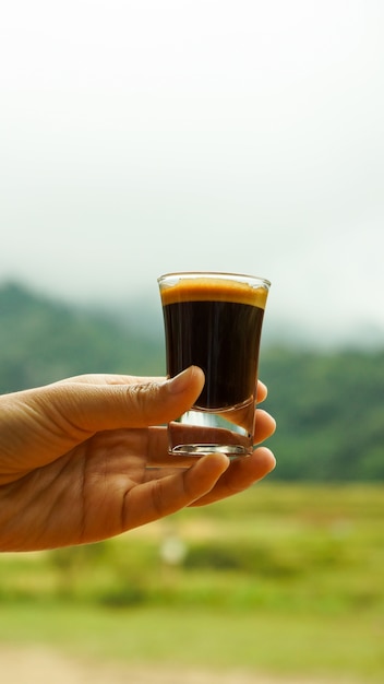 Frauenhand, die ein Glas Kaffee hält