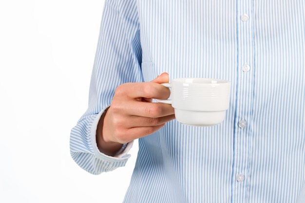 Frauenhand, die Kaffeetasse hält. Geschäftsfrau mit weißer Kaffeetasse. Tolle morgendliche Erfrischung. Zeit für eine Pause.