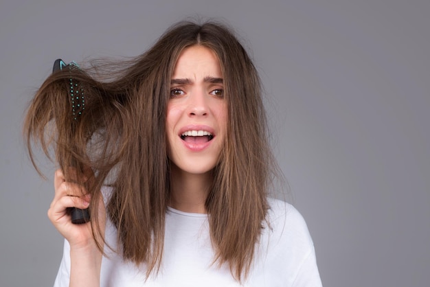 Frauenhand, die Kamm mit ernstem Haarausfallproblem für Gesundheitspflegeshampoo hält