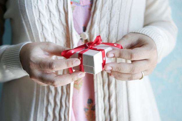 Frauenhand, die kleine herzförmige Geschenkbox hält