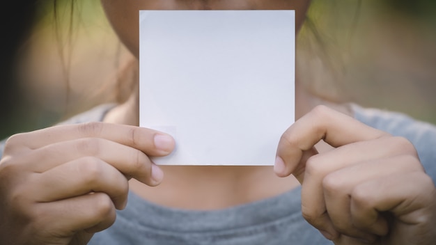 Frauenhand, die leeres Papierblatt hält