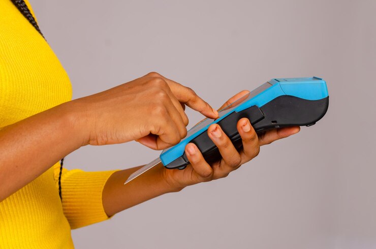 Frauenhand, die mit Smartphone am Kreditkarten-POS-Terminal bezahlt