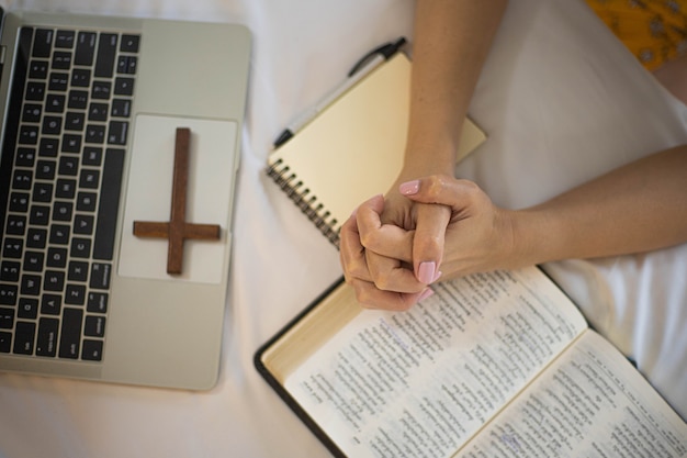 Frauenhand, die morgens auf heiliger Bibel betet Studieren Sie die Bibel mit Online-Gottesdienst.