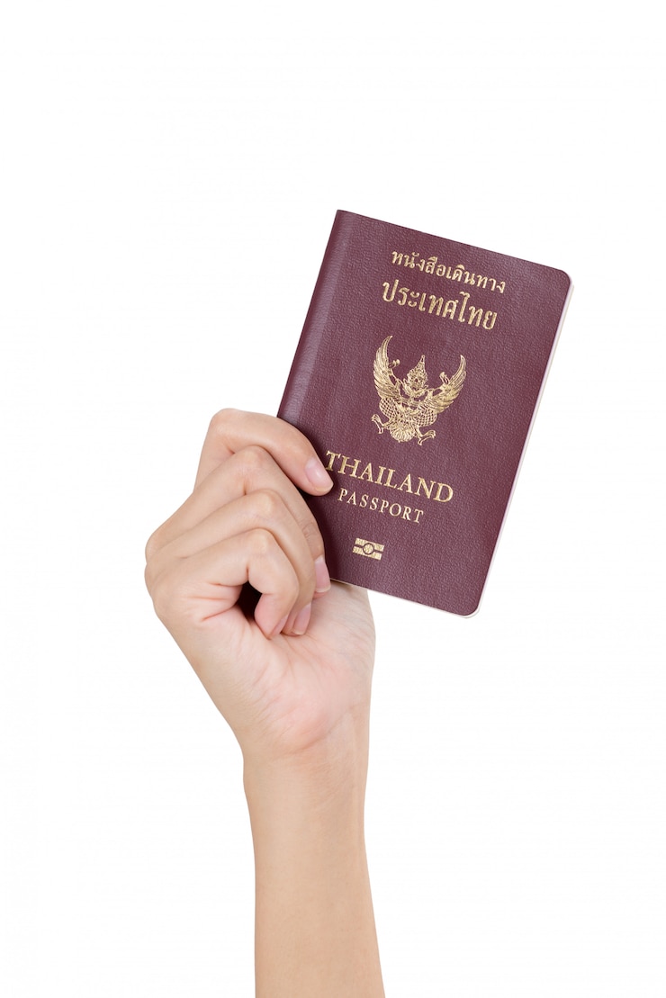Foto frauenhand, die thailändischen pass lokalisiert auf weiß hält