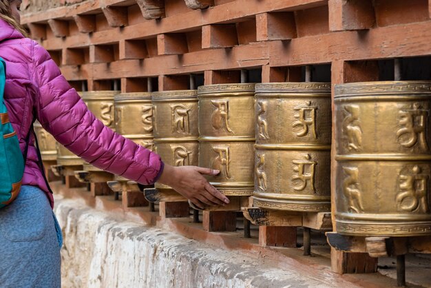 Frauenhand, die tibetanische buddhistische Gebetsräder, Indien dreht.