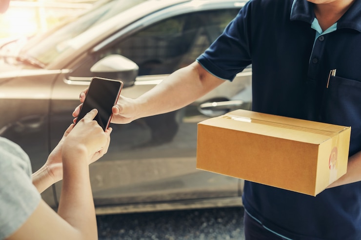 Foto frauenhand, die unterzeichnung im handy für das empfangen des pakets anfügt