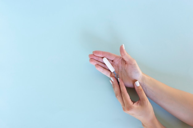 Frauenhand hält einen Hygienetampon