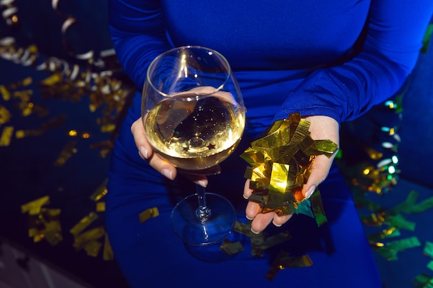 Frauenhand hält Glas Champagner auf einer Geburtstagsfeier am Abend