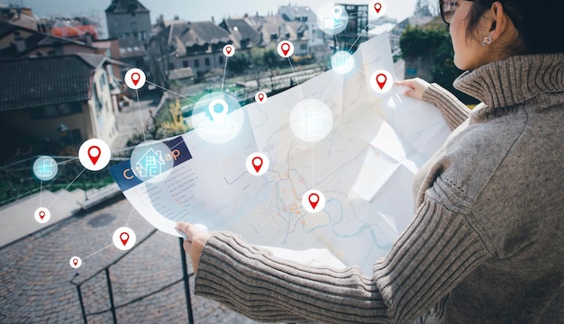 Frauenhand halten Kartenstadt für Reise- und Modellkarte mit Standortpunkt GPS-App-Symbol Reisekarten und Orte finden im Online-System Alle Bildschirmgrafiken werden generiertSuche nach Reisezielen