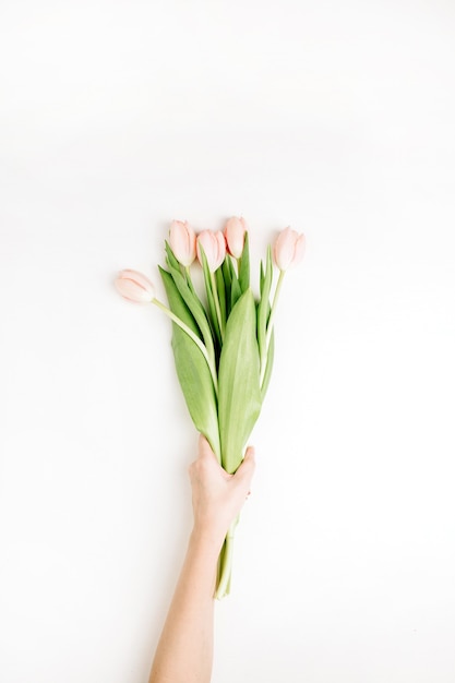 Frauenhand halten rosa Tulpenblumenstrauß