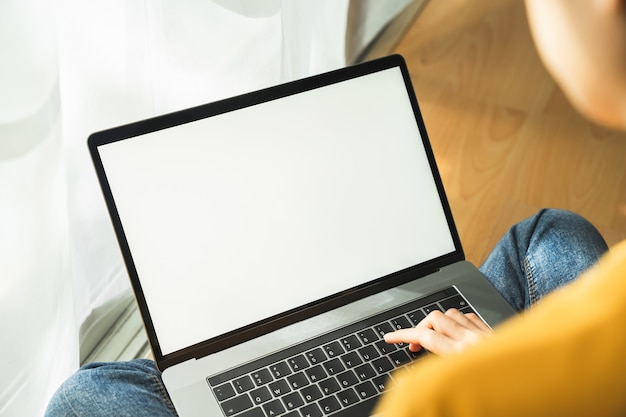 Frauenhand mit Laptop und Typ auf der Tastatur. Mockup-Bildschirm der Werbung.