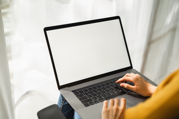 Frauenhand mit Laptop und Typ auf der Tastatur.