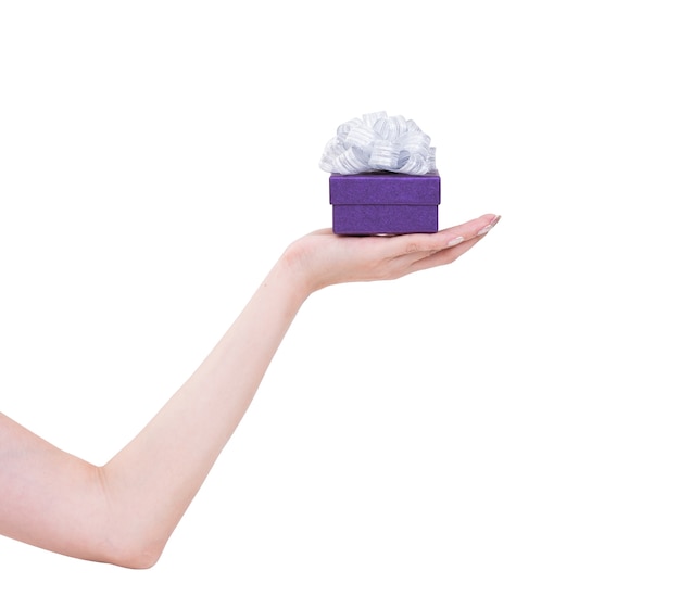 Frauenhand mit lila Geschenkbox lokalisiert auf Weiß