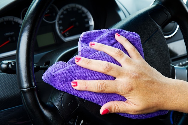 Frauenhand mit Mikrofasertuch Polierscheibe eines Autos