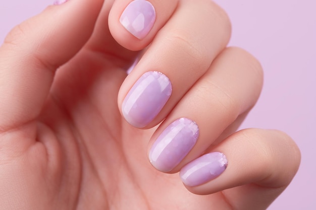Frauenhand mit trendigem Lavendel-Maniküre-Frühlings-Sommer-Nageldesign