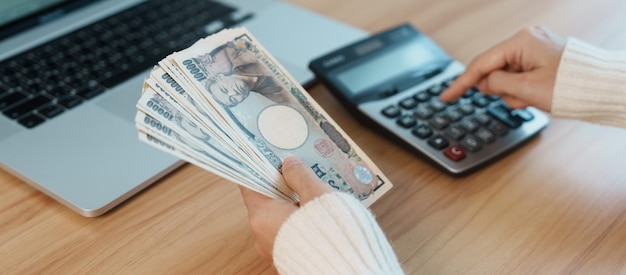 Frauenhand zählen japanische Yen-Banknote mit Taschenrechner Tausend Yen-Geld Japan-Bargeld Steuerrezession Wirtschaft Inflation Investitionsfinanzierung Gehalts- und Zahlungskonzepte