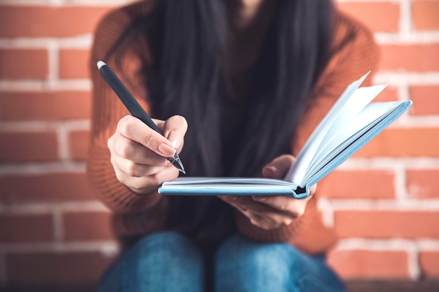 Frauenhandnotizblock mit Stift