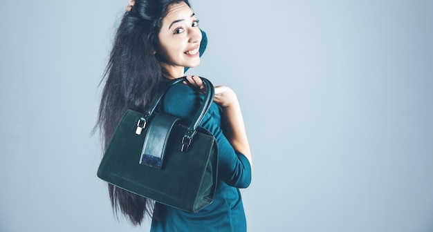 Frauenhandtasche hinten auf grauem Hintergrund