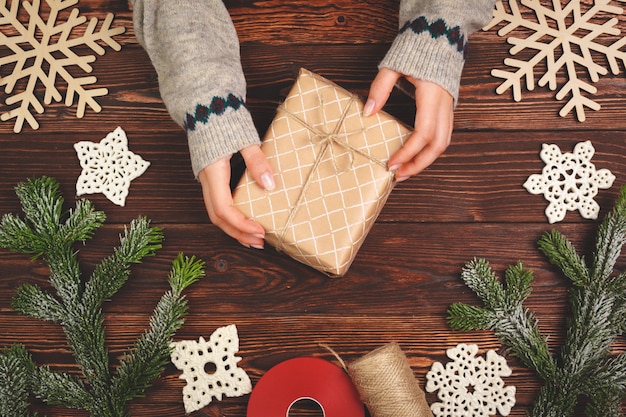 Frauenholding eingewickeltes Weihnachtsgeschenk in ihren Händen, Ansicht von oben