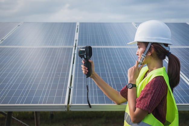 Fraueningenieur, der Wärmebildkamera verwendet, um Temperaturhitze des Sonnenkollektors zu überprüfen