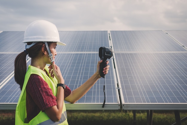 Fraueningenieur, der Wärmebildkamera verwendet, um Temperaturhitze des Sonnenkollektors zu überprüfen