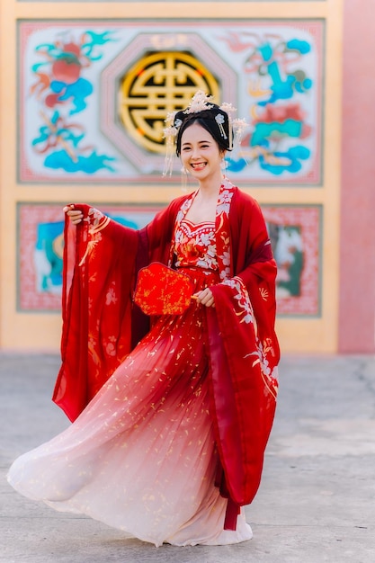 Frauenkleidung China Neujahrsporträt einer Frau in traditioneller Kleidung Frau in traditionelle Kleidung Schöne junge Frau in einem leuchtend roten Kleid und einer Krone der chinesischen Königin posiert