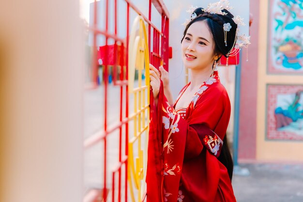 Frauenkleidung China Neujahrsporträt einer Frau in traditioneller Kleidung Frau in traditionelle Kleidung Schöne junge Frau in einem leuchtend roten Kleid und einer Krone der chinesischen Königin posiert