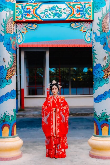 Frauenkleidung China Neujahrsporträt einer Frau in traditioneller Kleidung Frau in traditionelle Kleidung Schöne junge Frau in einem leuchtend roten Kleid und einer Krone der chinesischen Königin posiert