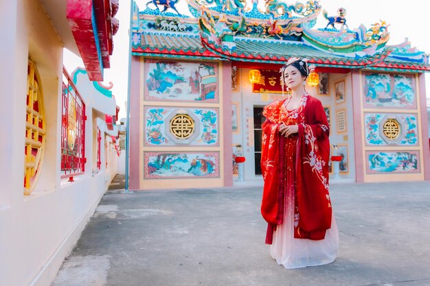 Frauenkleidung China Neujahrsporträt einer Frau in traditioneller Kleidung Frau in traditionelle Kleidung Schöne junge Frau in einem leuchtend roten Kleid und einer Krone der chinesischen Königin posiert