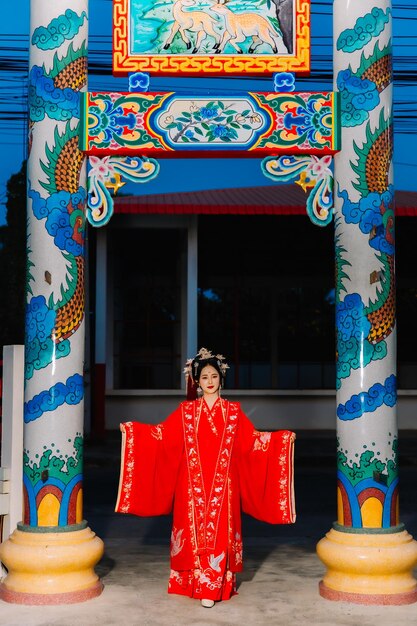 Frauenkleidung China Neujahrsporträt einer Frau in traditioneller Kleidung Frau in traditionelle Kleidung Schöne junge Frau in einem leuchtend roten Kleid und einer Krone der chinesischen Königin posiert