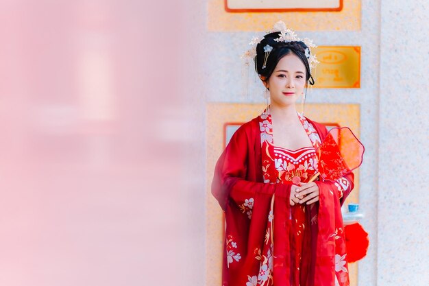 Frauenkleidung China Neujahrsporträt einer Frau in traditioneller Kleidung Frau in traditionelle Kleidung Schöne junge Frau in einem leuchtend roten Kleid und einer Krone der chinesischen Königin posiert