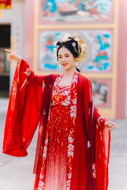 Frauenkleidung China Neujahrsporträt einer Frau in traditioneller Kleidung Frau in traditionelle Kleidung Schöne junge Frau in einem leuchtend roten Kleid und einer Krone der chinesischen Königin posiert