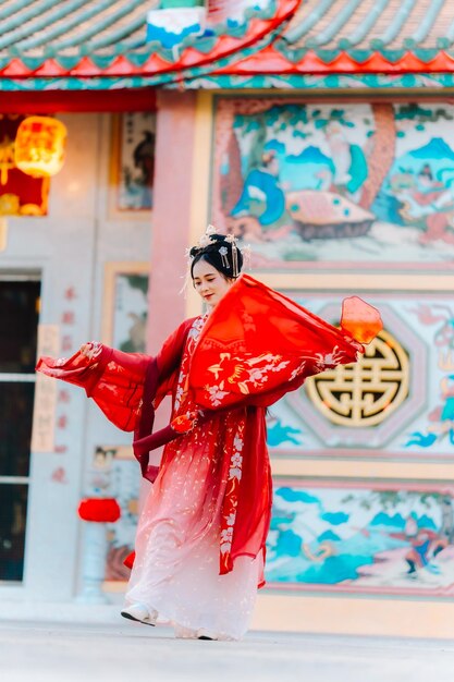 Frauenkleidung China Neujahrsporträt einer Frau in traditioneller Kleidung Frau in traditionelle Kleidung Schöne junge Frau in einem leuchtend roten Kleid und einer Krone der chinesischen Königin posiert