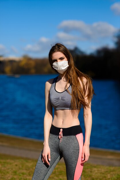 Frauenläufer Morgenübung trägt sie eine Nasenmaske. Schutz vor Staub und Viren