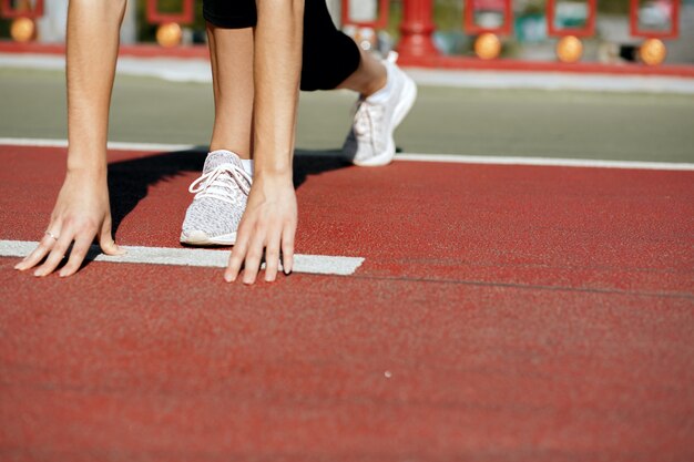 Foto frauenläuferin in der startposition bereit für den sprint. platz für text