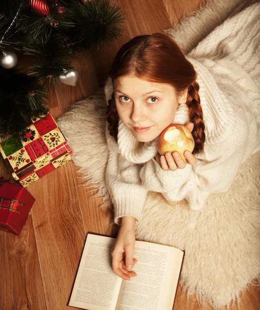 Frauenlesebuch auf Weihnachten vor Baum