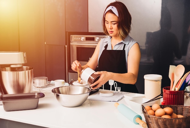 Frauenmädchen in der Küche, die thailändischen Tee kocht