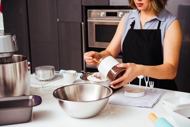 Frauenmädchen in der Küche, die thailändischen Tee kocht