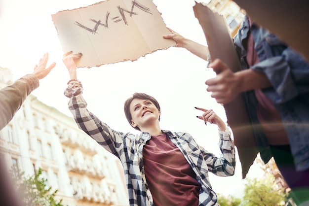 Frauenmarschgruppe glücklicher und junger Aktivistinnen, die für Gleichberechtigung auf der Straße protestieren