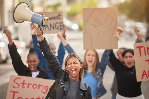 Frauenmegaphon und Faust in der Gemeinschaft protestieren für Gleichberechtigung, Menschenrechte oder wirtschaftlichen Wandel in der Stadt Wütende Frauen stehen zusammen und marschieren auf der Straße für Streikstimme oder Plakatbotschaft