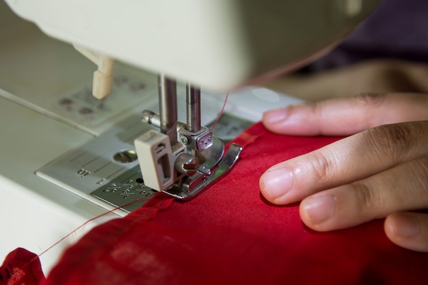 Frauennäherin, die Kleidung auf einer Nähmaschine machend arbeitet.